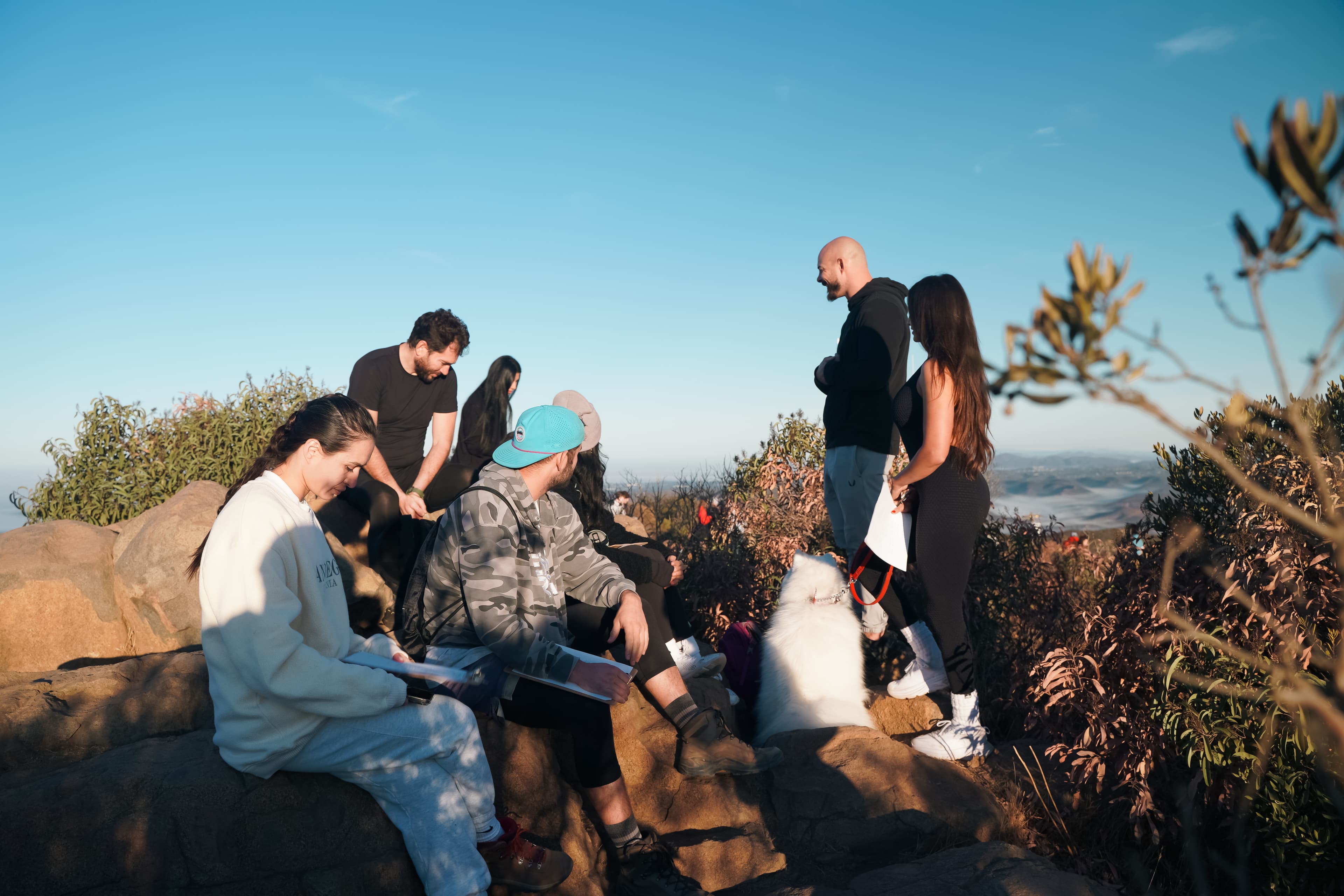 Men journaling and training outdoors at a mountaintop session