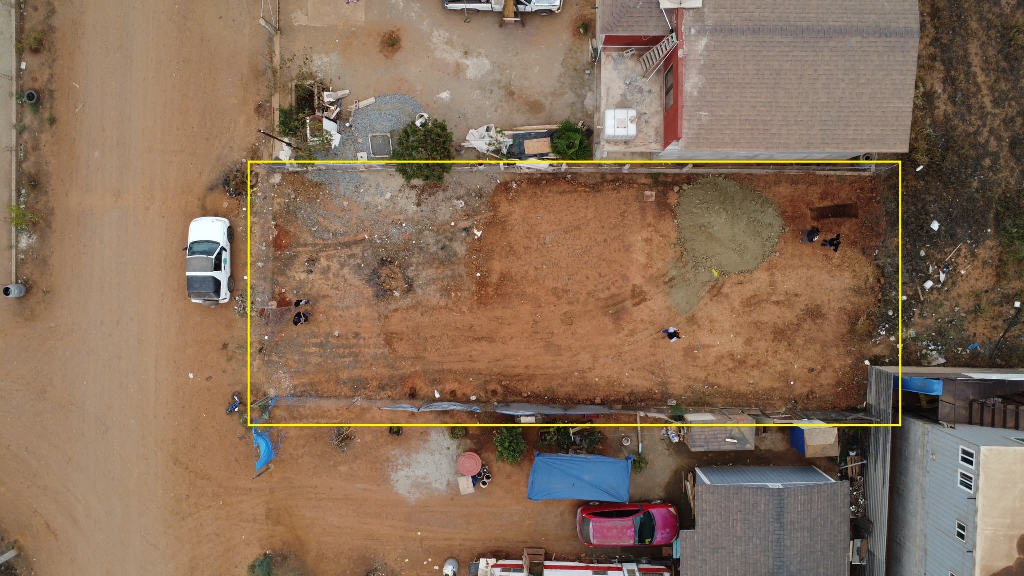 Aerial drone view of the dirt lot in Ensenada where the Pérez Vázquez family home will be built, property lines marked in yellow